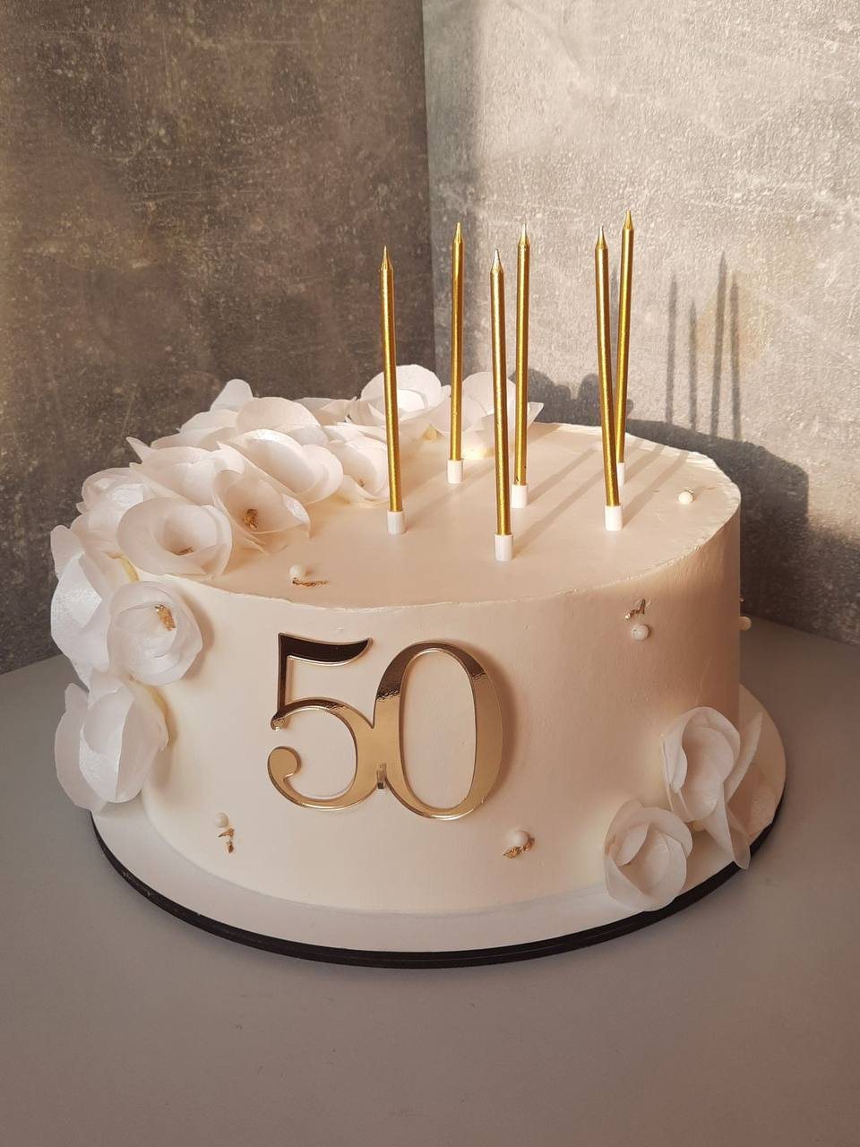 Юбилейный торт с золотыми свечами и цифрой 50